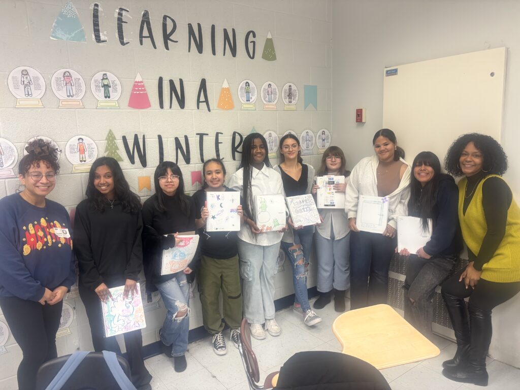 Teen girls pose with artwork they created.