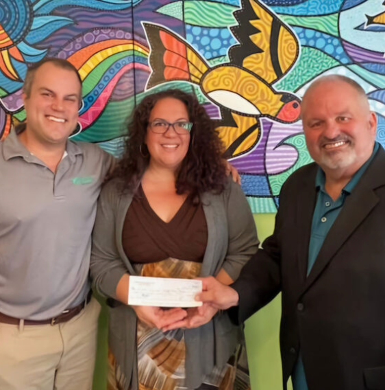 Conor Evans, Dominique Tornabe, and Tom Werder pose with a check from Community Builders.